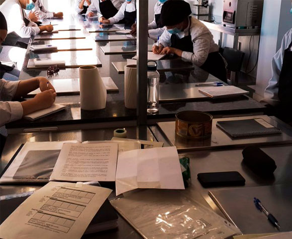 Persones en situació de vulnerabilitat participant en formació com a ajudants de cuina.